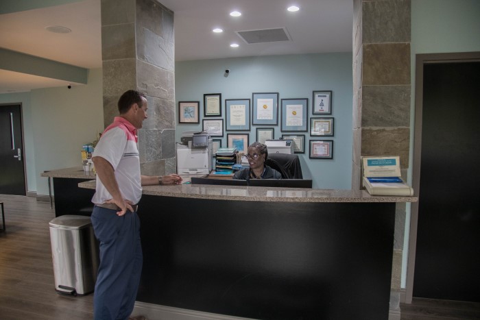 A man talks to an employee at a desk in Wilmington Treatment Center