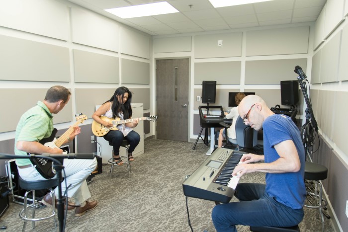 A group of people playing instruments in the music recording room at Wilmington Treatment Center