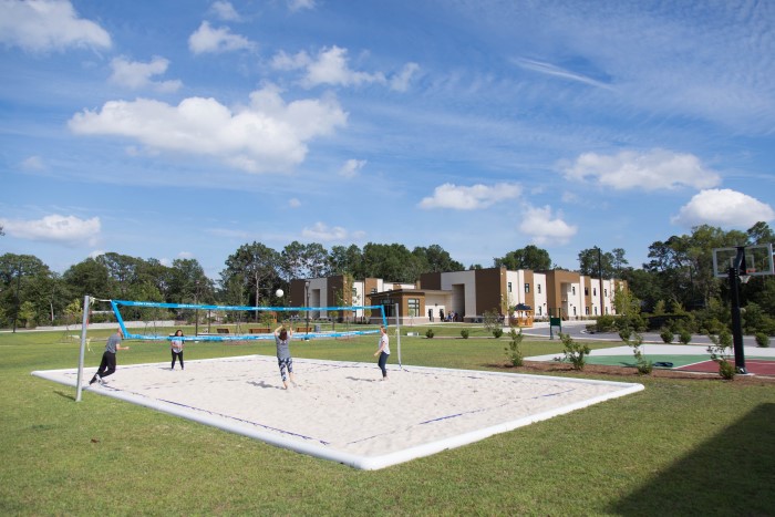 People playing volleyball on a sand court outside at Wilmington Treatment Center